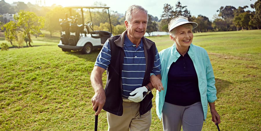 An older couple walking the golf course together