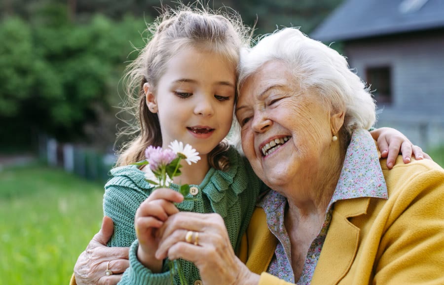 Grandmother laughing with her granddaughter outdoors