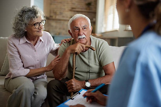 A provider meeting with an older couple in their living room